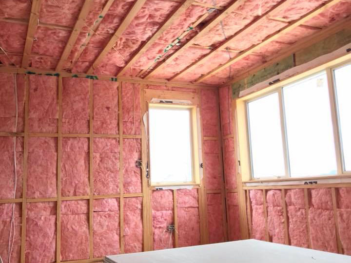 pink insulation in uncovered wall and ceiling of a room